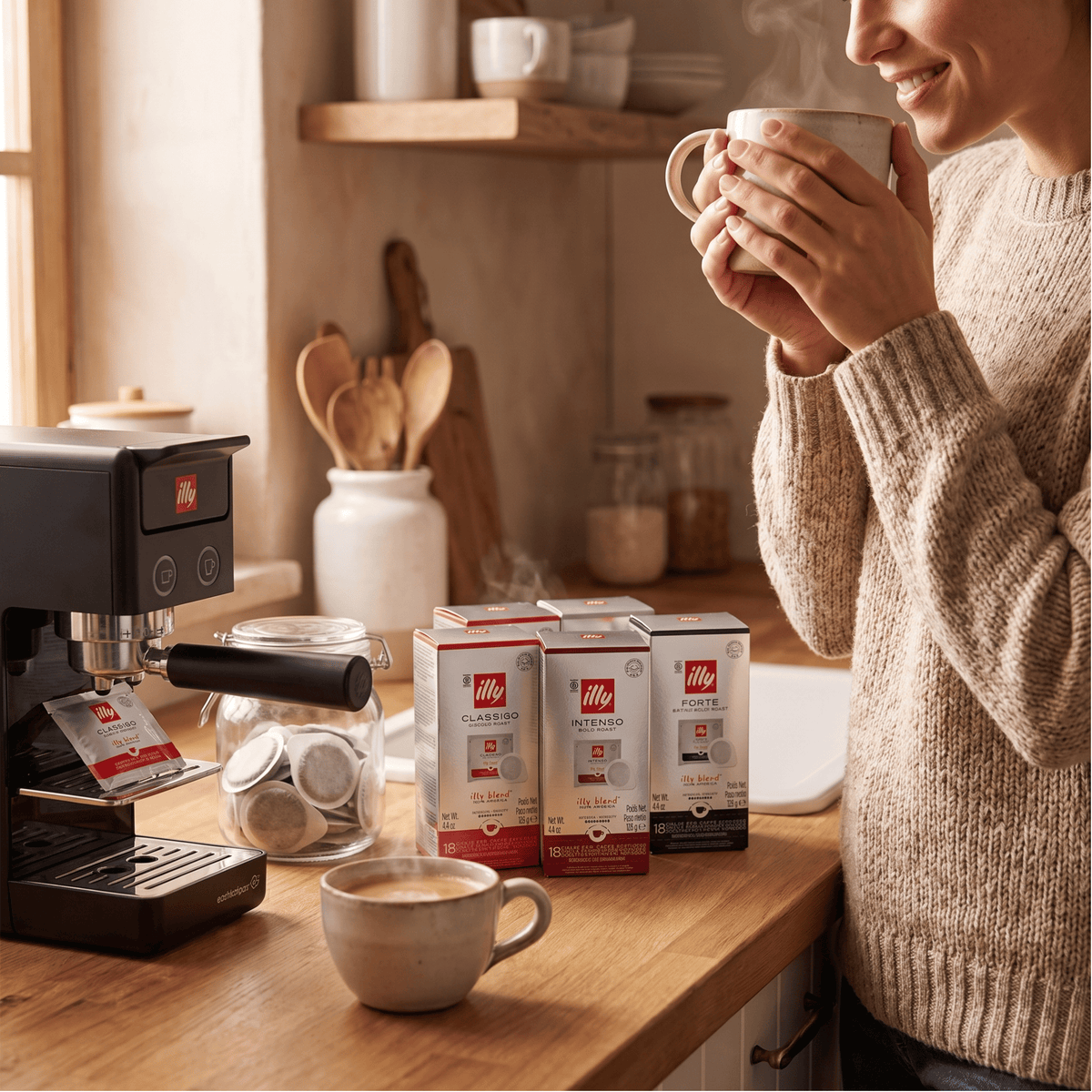 Person preparing coffee in an office pantry using illy E.S.E. coffee pods and E.S.E. coffee machine